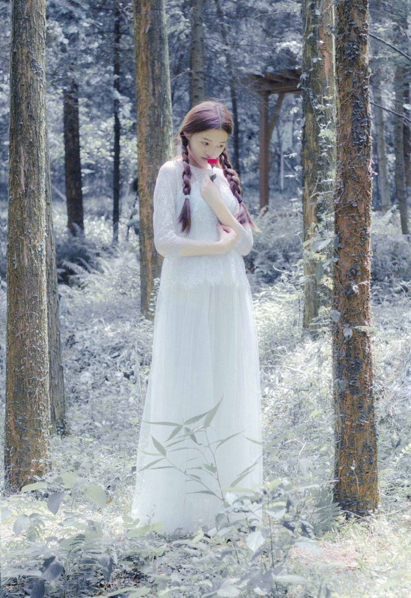 点击大图看下一张：丛林处的白裙麻花辫美女静谧温柔