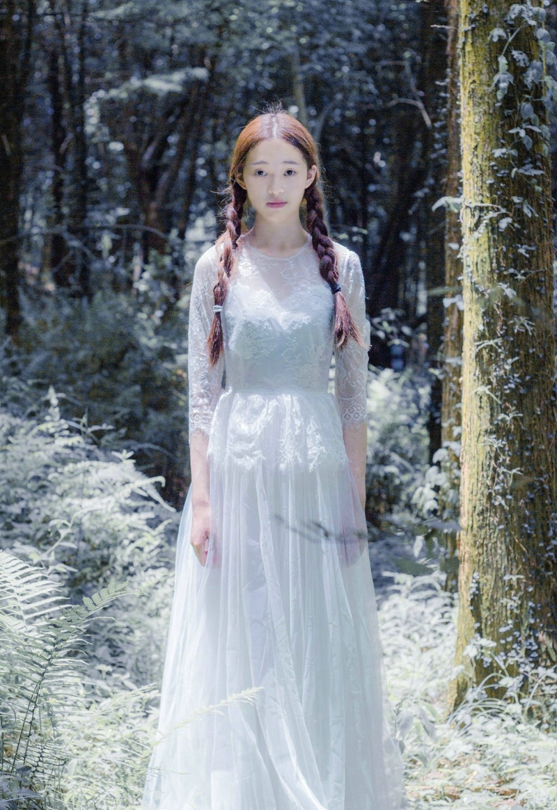 点击大图看下一张：丛林处的白裙麻花辫美女静谧温柔