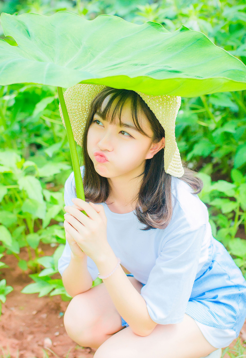 点击大图看下一张：草丛中的草帽少女甜美可人