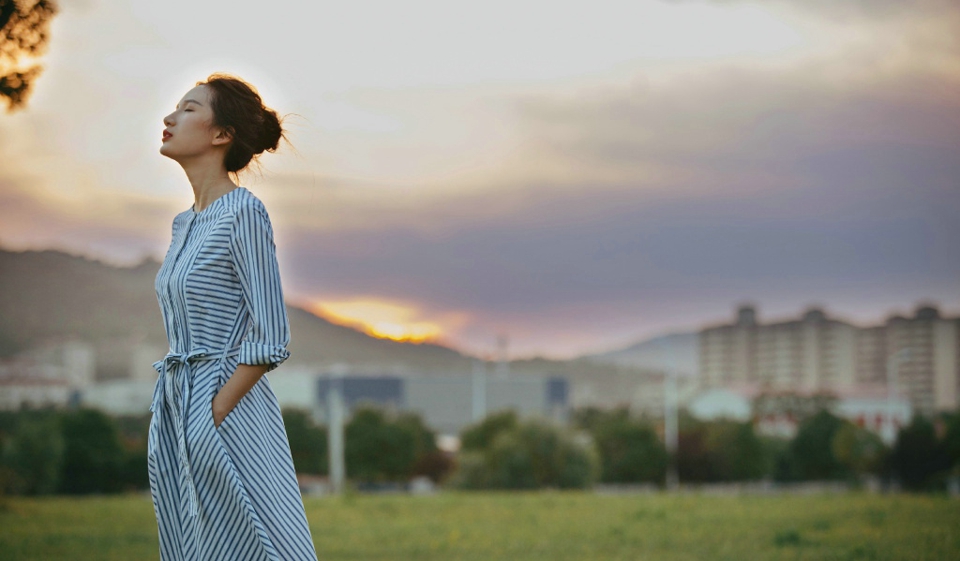 点击大图看下一张:黄昏草地上的丸子头连衣裙高颜值美女