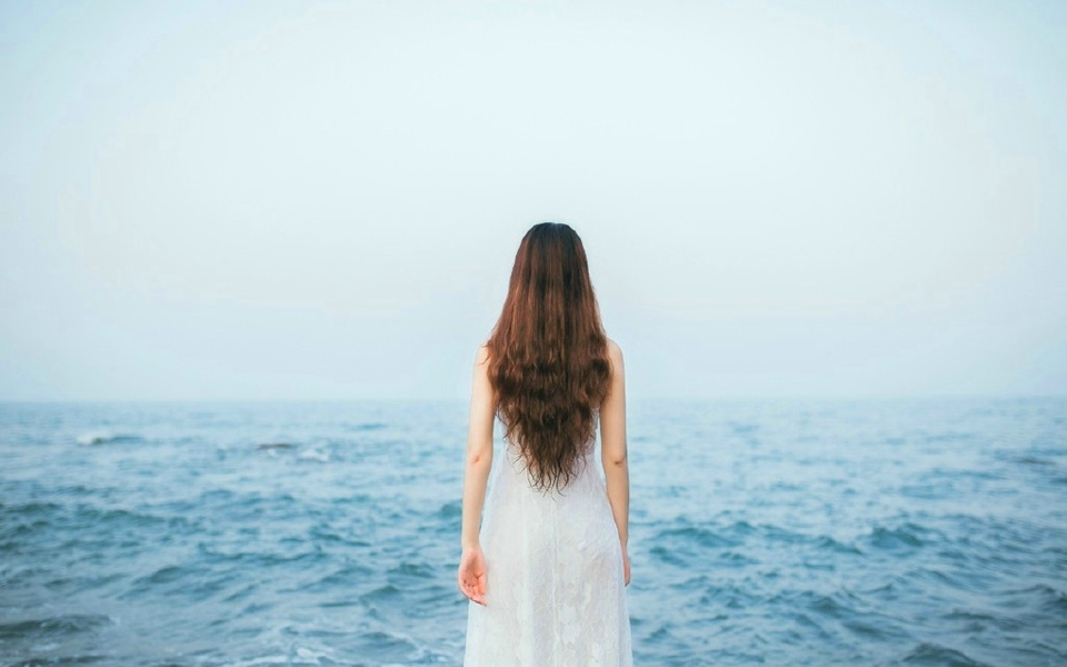 点击大图看下一张：海岸边的白裙长发女神气质张扬