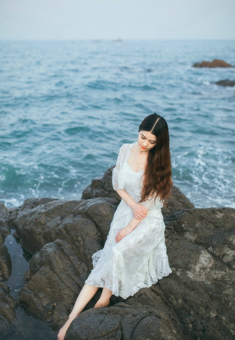 点击大图看下一张：海岸边的白裙长发女神气质张扬