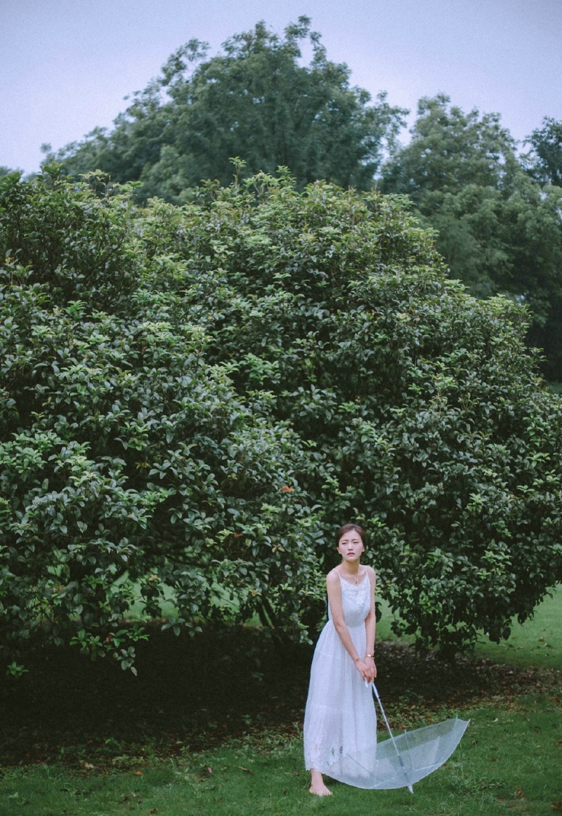 点击大图看下一张：雨天树林内的白裙柔美淡雅美女