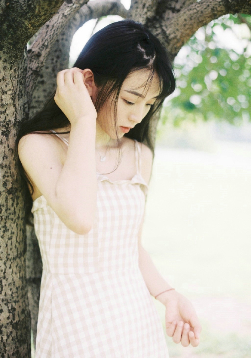 点击大图看下一张：草地上的格子裙长发甜美少女漂亮吸睛