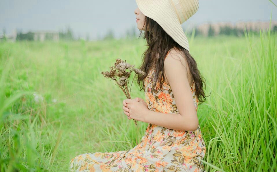 点击大图看下一张：草地上的长裙草帽美女明媚笑容