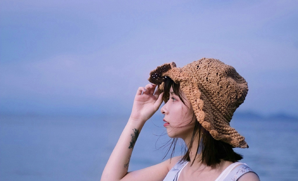 点击大图看下一张：海岸边的草帽美女柔美可人写真