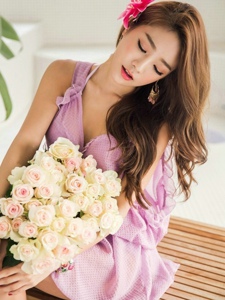 身着紫罗兰连衣裙模特清新淡雅捧花闻芳香很迷人
