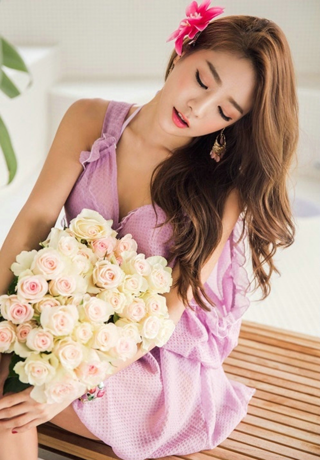 点击大图看下一张：身着紫罗兰连衣裙模特清新淡雅捧花闻芳香很迷人