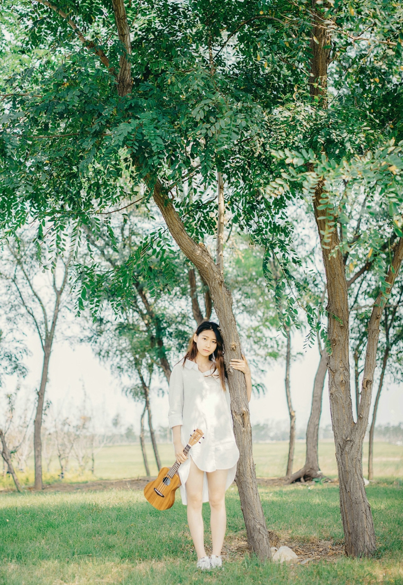 点击大图看下一张：草地上的尤克里里白衬衫美女纯真图片