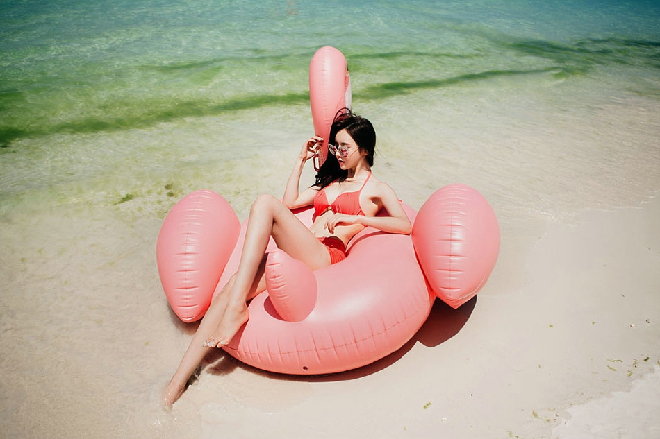 点击大图看下一张：沙滩比基尼墨镜美模躺在游泳圈上晒阳光