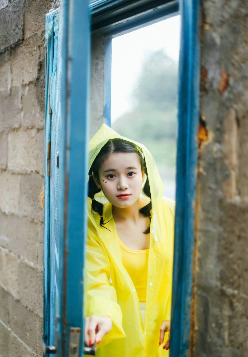 点击大图看下一张：雨天街头山上的黄色雨衣萌妹子嘟嘴卖萌
