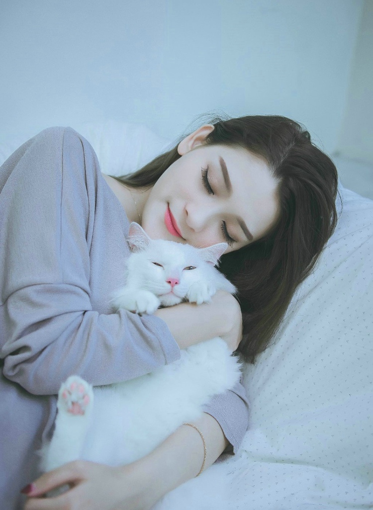 点击大图看下一张：大眼美模床上抱着猫咪熟睡安静迷人
