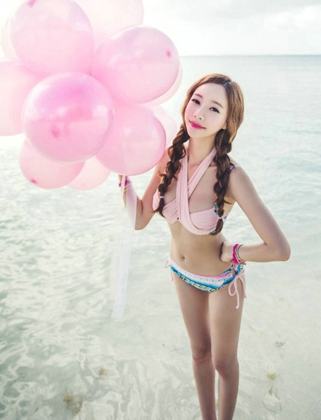 点击大图看下一张：美腿嫩模粉色比基尼海边写真手拿气球满脸享受
