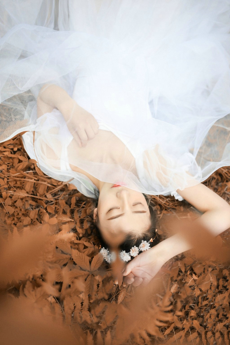 点击大图看下一张：深秋落叶堆中的白纱裙气质盘发美女
