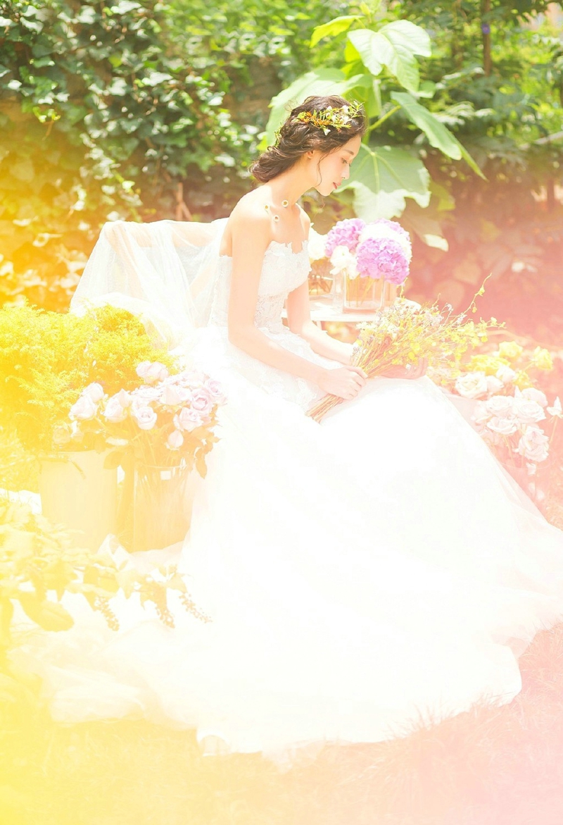 点击大图看下一张：花丛中的婚纱盘发女神气质养眼写真