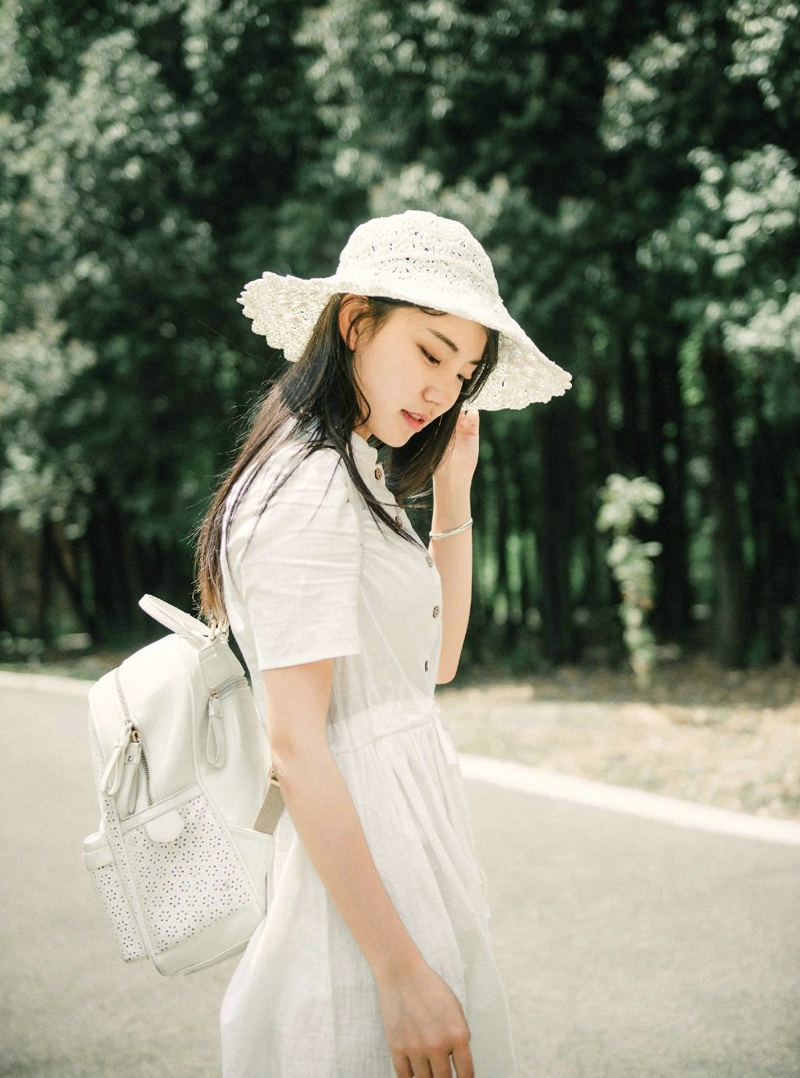 点击大图看下一张：森林公园内的白裙草帽背包少女清爽怡人