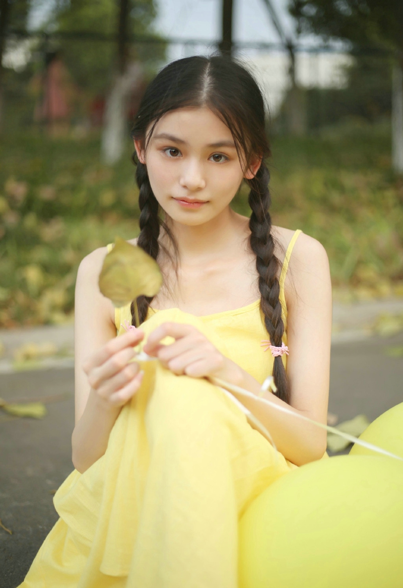 点击大图看下一张：草地上的黄色靓丽连衣裙麻花辫姑娘美丽动人