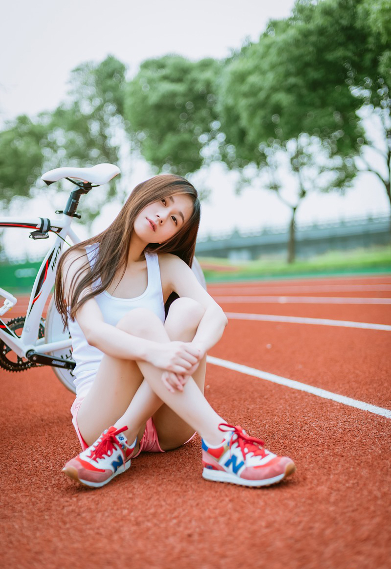 点击大图看下一张：清新夏日跑道场上的单车少女清纯写真