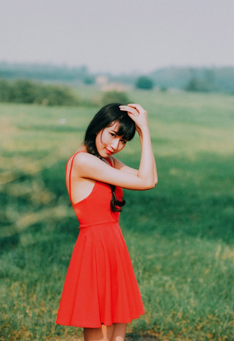 点击大图看下一张：郊外草坪上的吊带红裙娇艳女神美背怡人
