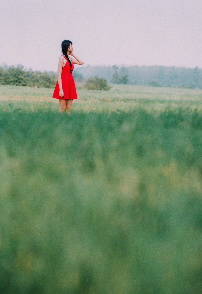 点击大图看下一张：郊外草坪上的吊带红裙娇艳女神美背怡人