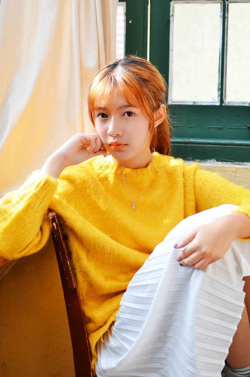 点击大图看下一张：穿黄色毛衣的刘海邻家美女温馨阳光迷人写真