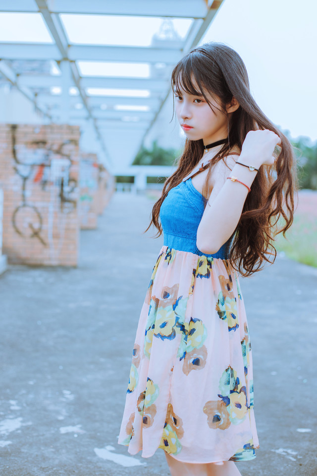 点击大图看下一张：齐刘海少女吊带碎花裙坐在草丛中甜美娇俏