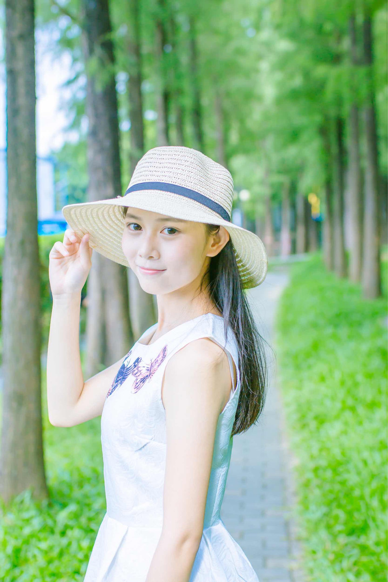 点击大图看下一张：森林公园里戴太阳帽的美女阳光温馨写真