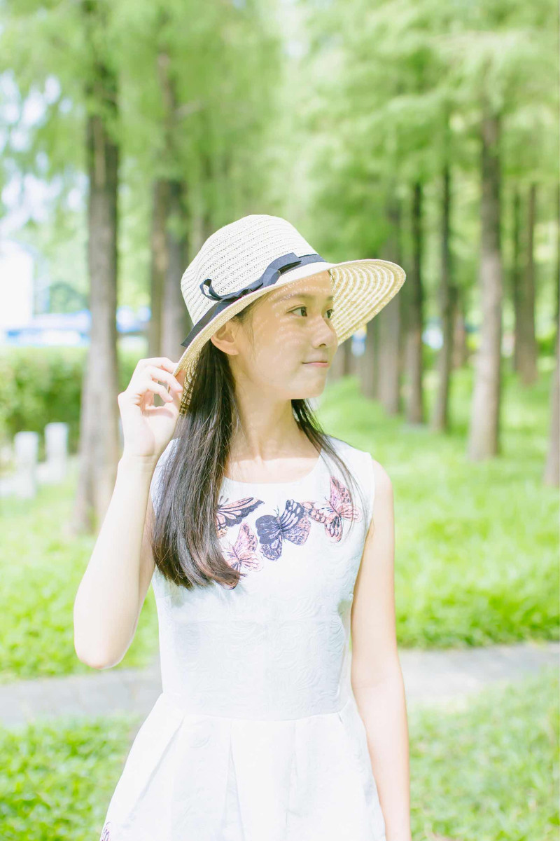 点击大图看下一张：森林公园里戴太阳帽的美女阳光温馨写真