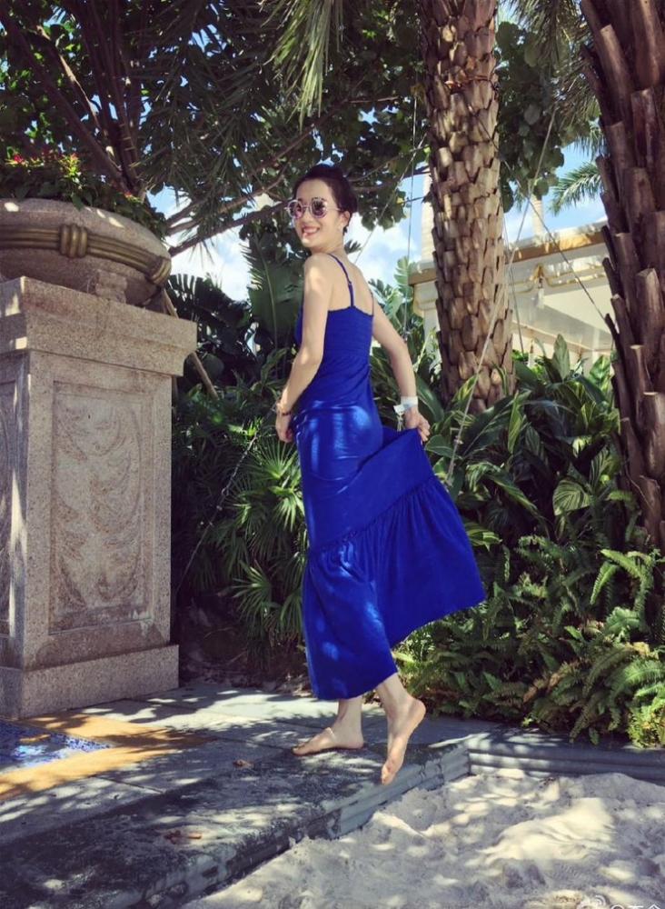 点击大图看下一张：李念穿吊带长裙现身沙滩 墨镜红唇气场强