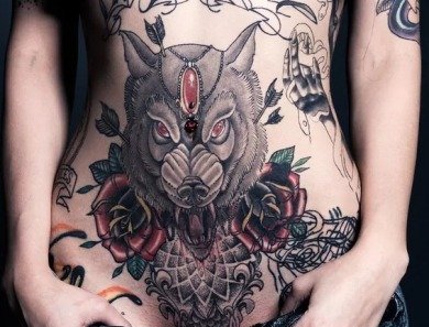 点击大图看下一张：女性下腹部玫瑰花和大狼纹身图片