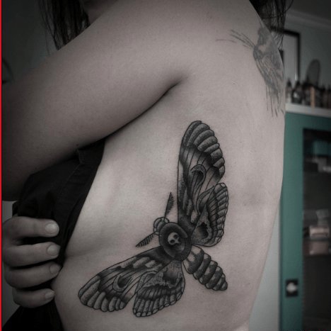 点击大图看下一张：女子左侧肋上帅气的黑灰色飞蛾纹身图片