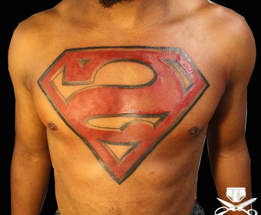 点击大图看下一张：男子满胸大红超人标志纹身图片