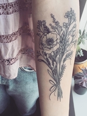 女孩手臂上精致的植物插花纹身图片