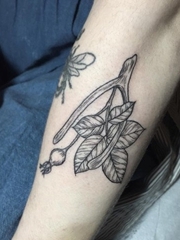 手前臂上精致的黑色点刺野玫瑰果纹身图案