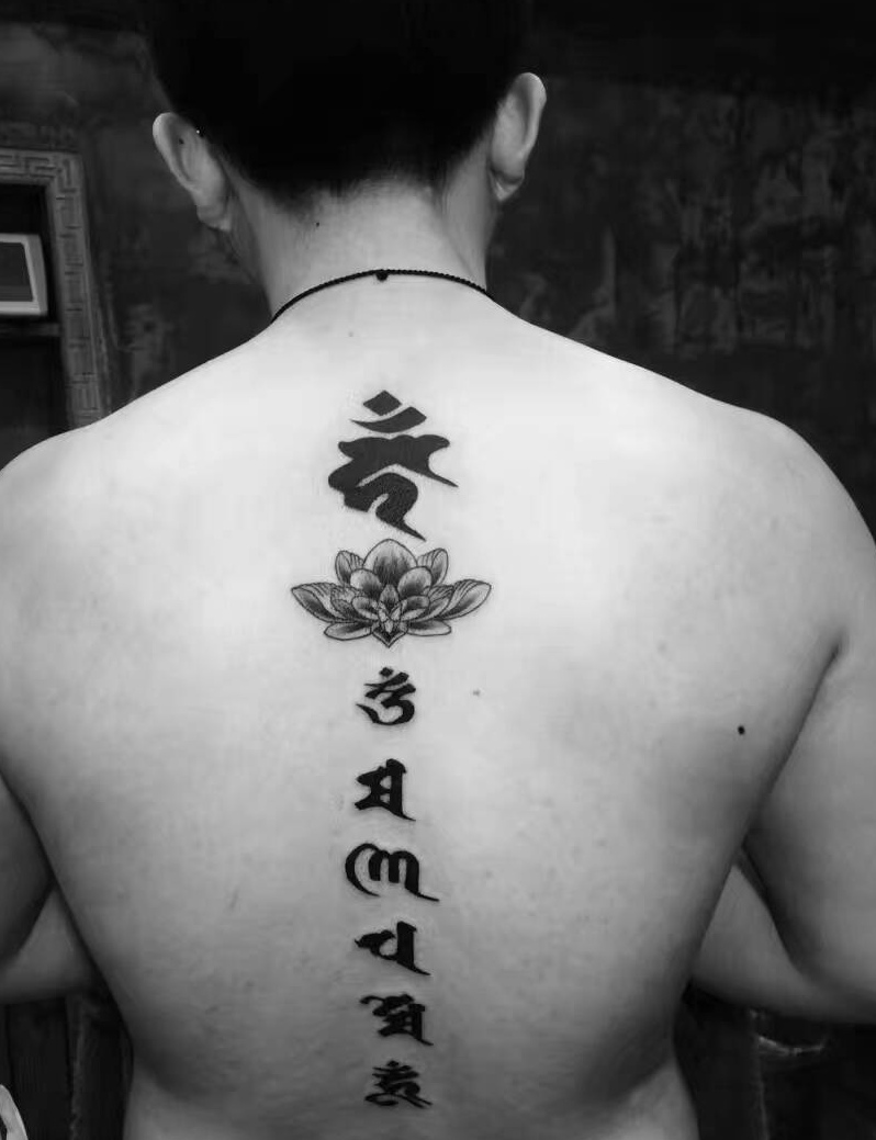 点击大图看下一张：莲花与梵文一起的背部脊椎纹身图案