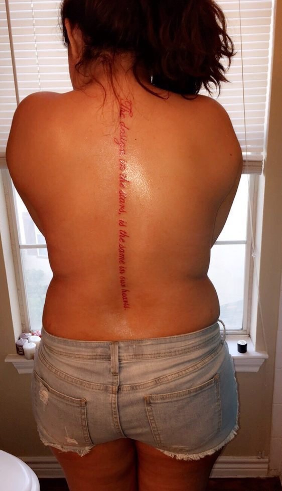 点击大图看下一张：女子背部脊椎骨上一行红色的英文字纹身图片