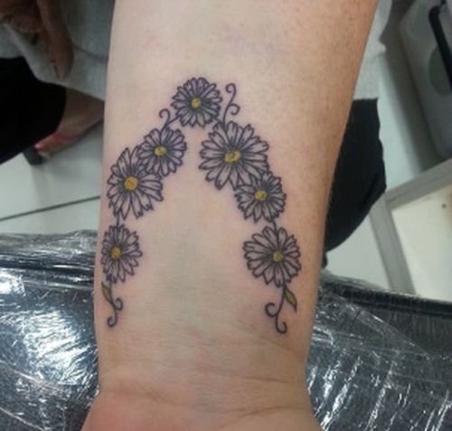 点击大图看下一张：30多款女性身上漂亮的雏菊花纹身图案