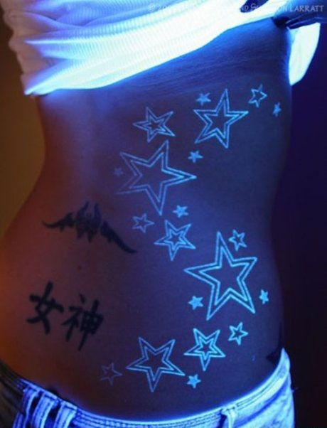 点击大图看下一张：女性腰部的荧光星星图案纹身