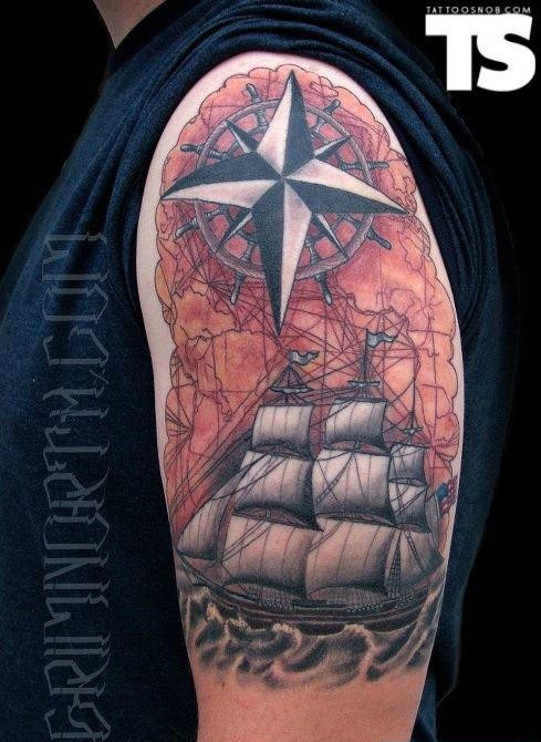 点击大图看下一张：大臂上一款精细的帆船指南针纹身图案