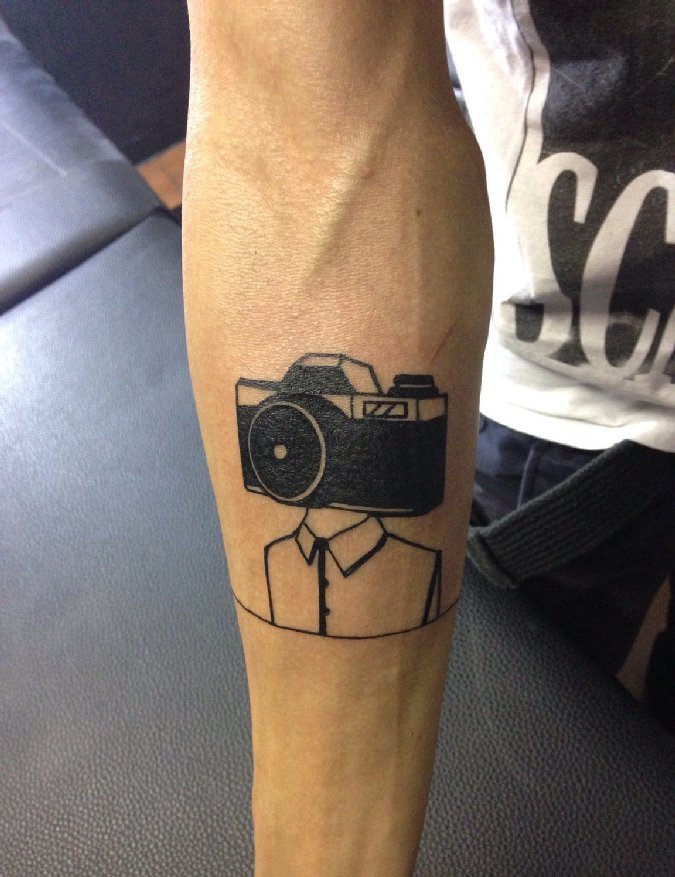 点击大图看下一张：男性右手臂上黑色相机头和人身纹身图片