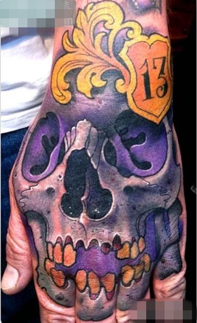 点击大图看下一张：手背上一张紫色骷髅纹身图案