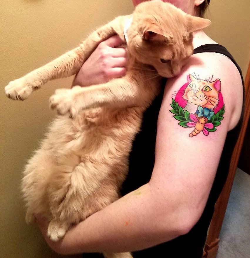 点击大图看下一张：女子左手大臂上漂亮的彩色宠物猫纹身图片
