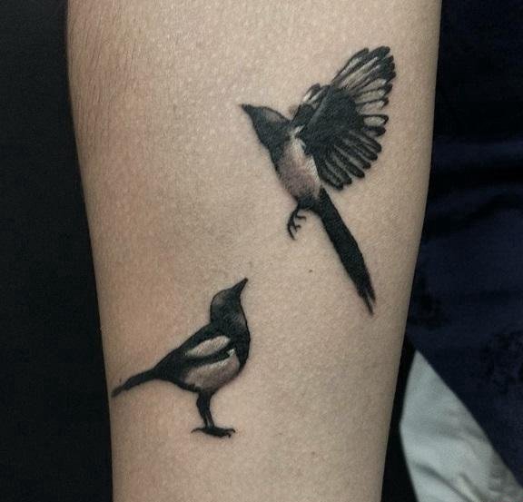 点击大图看下一张：手前臂上的一对可爱的喜鹊纹身图片