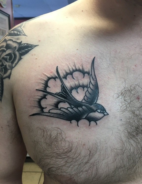 点击大图看下一张：男性胸部上的黑色飞翔中的燕子纹身图片