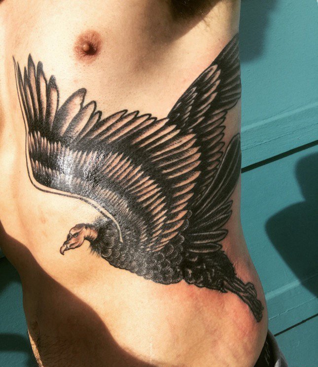 点击大图看下一张：男子左肋黑色霸气的秃鹰纹身图案