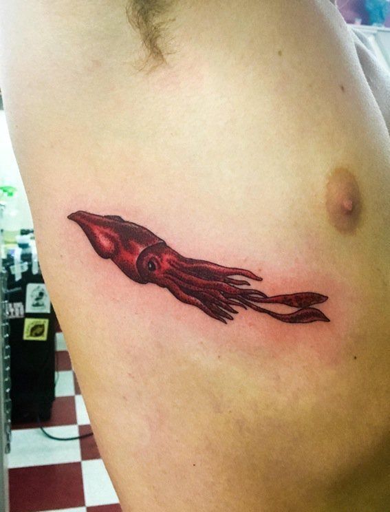 点击大图看下一张：男性右肋上红色的巨型乌贼纹身动物图案纹身