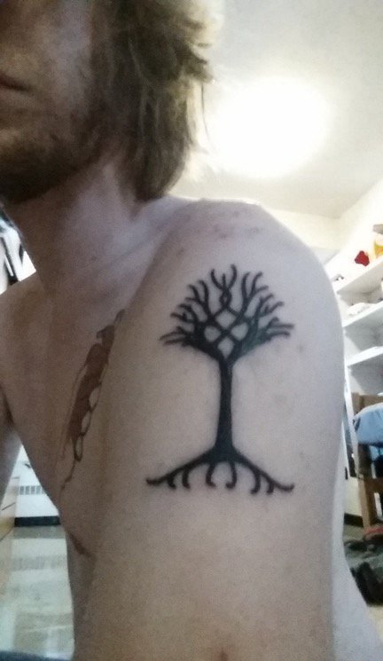 点击大图看下一张：男性左手臂上黑色的小树图腾纹身图片