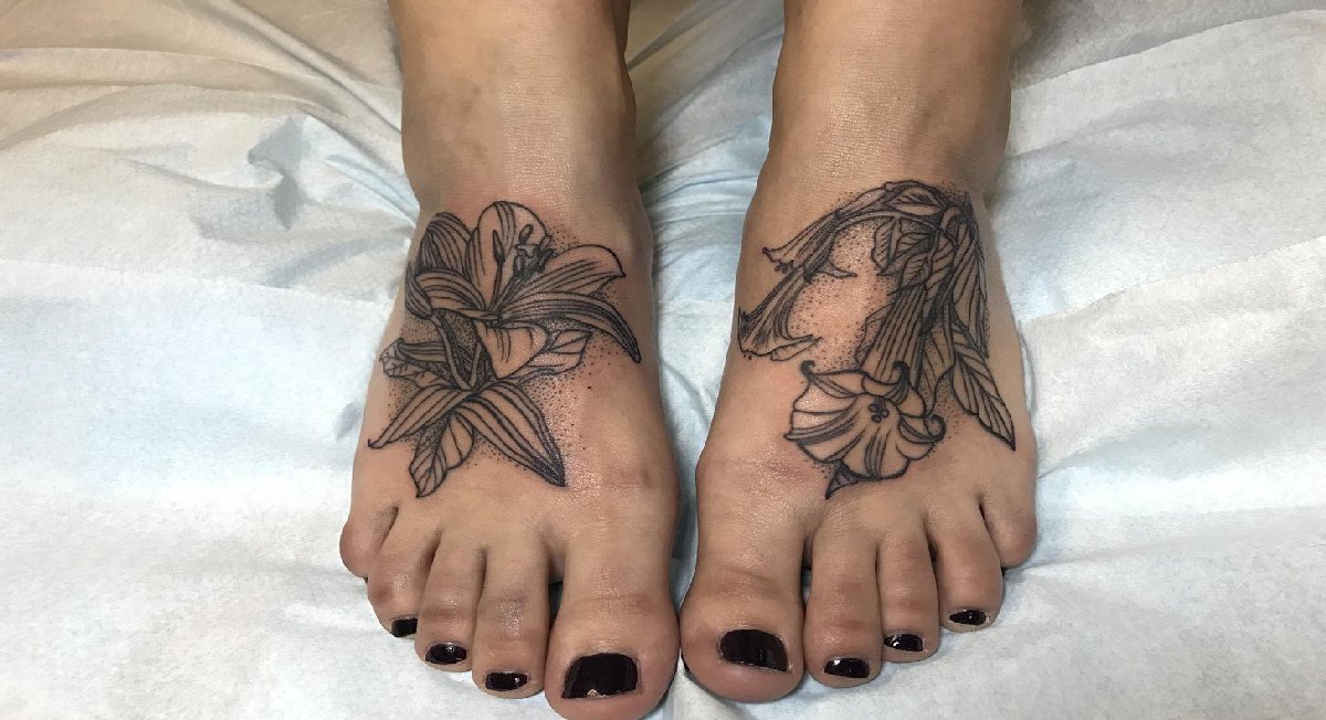 点击大图看下一张：女性脚背上黑色的植物纹身小花朵纹身图片
