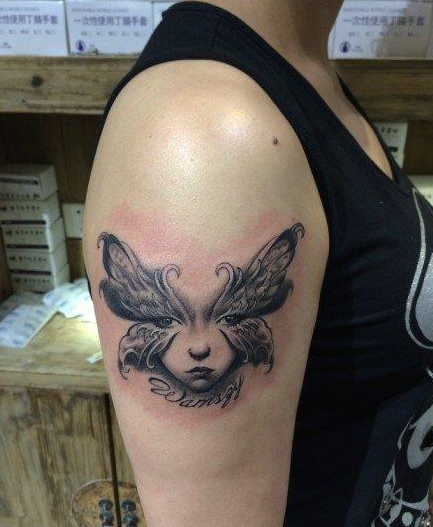 点击大图看下一张：女性手臂上黑灰蝴蝶面具纹身图案