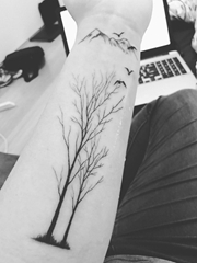 手臂上黑色山和鸟和枯树枝纹身图片